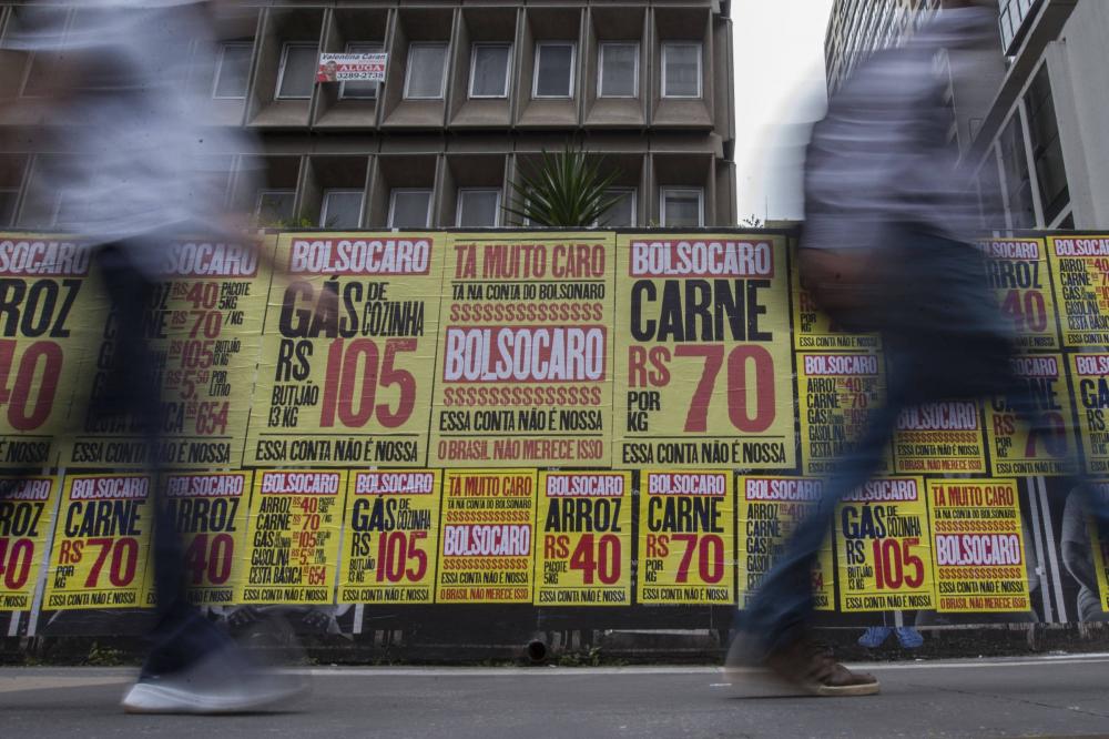 Pessoas circulam na capital paulista em frente a cartazes que criticam Bolsonaro pela alta de preços - Marlene Bergamo - 2.mar.2021/Folhapress