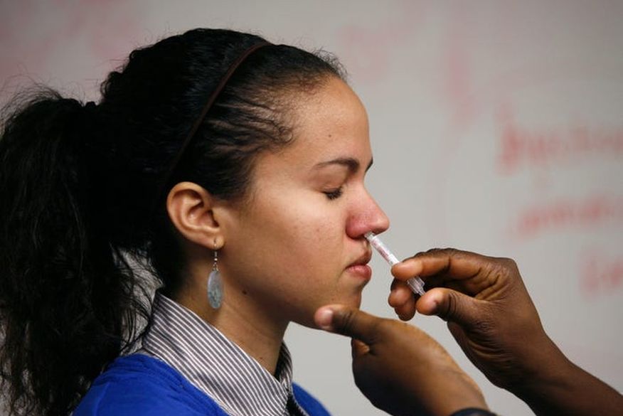 Em imagem de arquivo, a estudante Laura Delgado recebe dose de vacina em spray nasal contra o H1N1. — (Foto: Arquivo/Hyungwon Kang/Reuters).