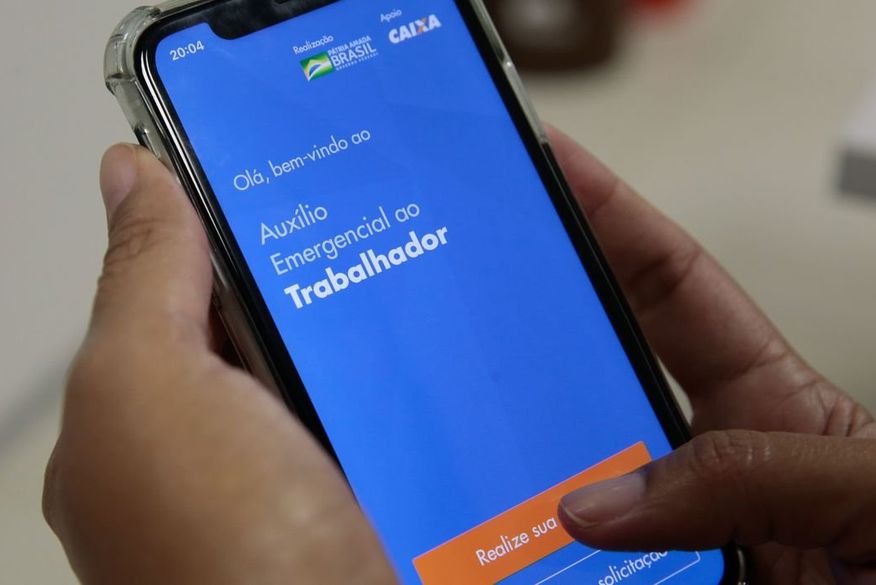 Os trabalhadores podem consultar a situação do benefício pelo aplicativo do auxílio emergencial ou pelo site auxilio.caixa.gov.br. (Foto: Reprodução)