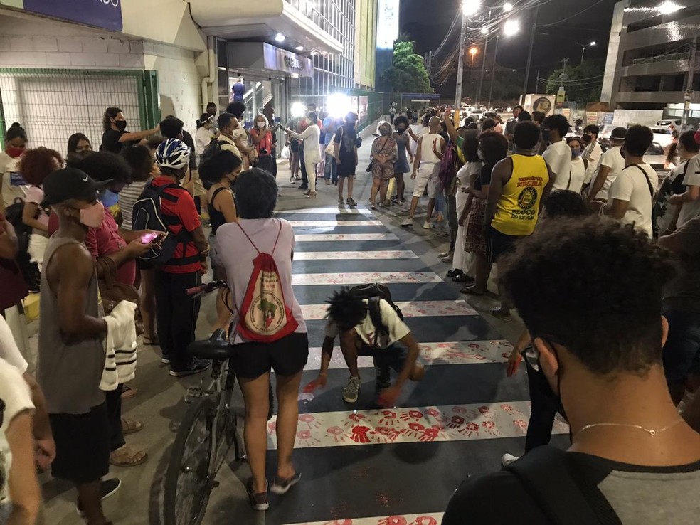 Mãos com tinta vermelha simbolizam o sangue do homem negro assassinado — Foto: Marco Aurélio Paz Tella