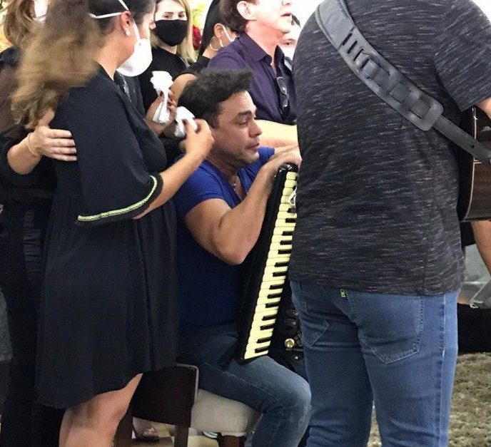 Zezé Di Camargo toma sanfona no sepultamento do pai. (Foto: Reprodução).