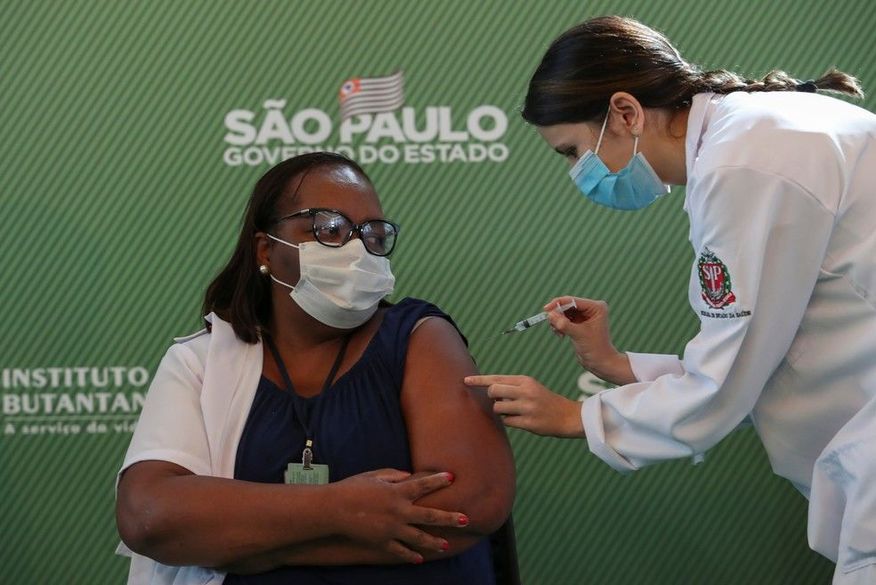 A enfermeira Mônica Calazans, de 54 anos, recebe uma dose da vacina CoronaVac contra a Covid-19 no Hospital das Clínicas, em São Paulo, depois que a Anvisa aprovou seu uso emergencial neste domingo (17). (Foto: Amanda Perobelli/Reuters).
